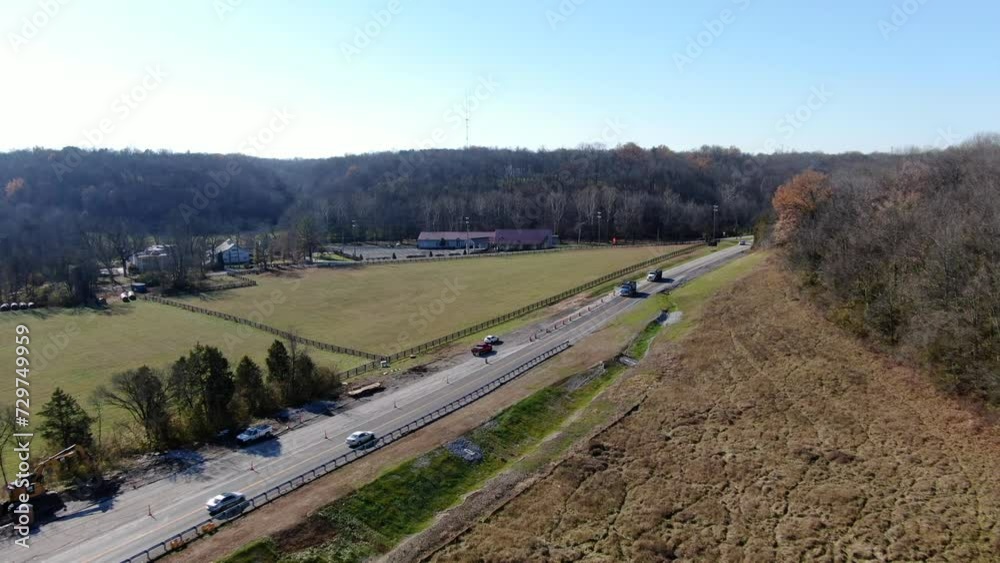 Aerial Shot of Cars Driving Along a Rural Highway Between Some Fields and Forests on a Sunny, Winter Day. Aerial Shot of Cars Driving Along a Rural Highway Between Some Fields and Forests on a Sunny, Winter Day.