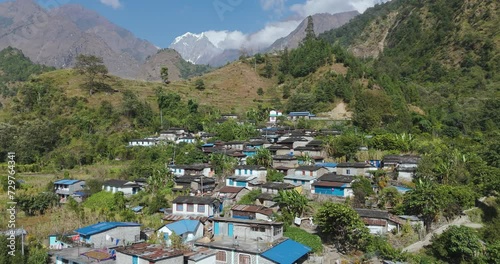 Drone shot of Nepali Village at Annapurna region, Mountain in background with Inhabitation of diverse ethnic citizens in Pokhara Nepal, Landscape in sunny weather 4K photo