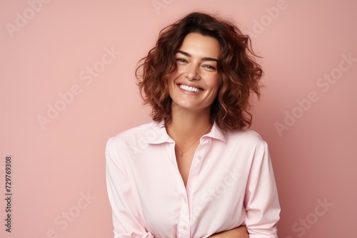 Portrait of a smiling young woman looking at camera against pink background