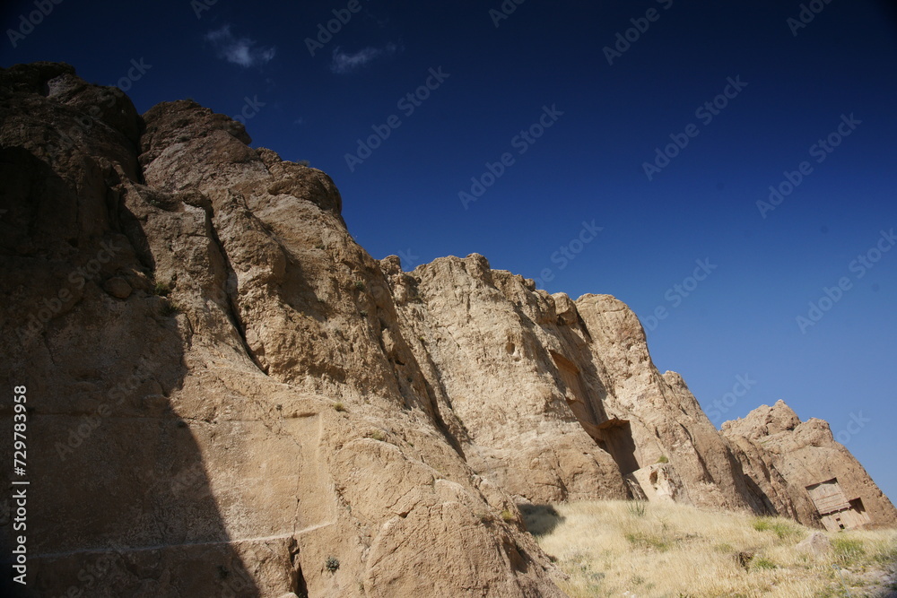 Naqsh-e Rostam is an ancient necropolis located about 12 km northwest of Persepolis, in Fars Province, Iran, with a group of ancient Iranian rock reliefs cut into the cliff.