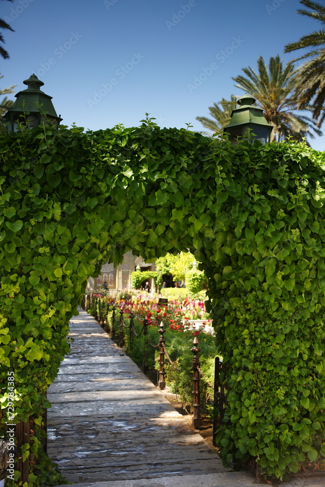 Fototapeta premium Woven plant branches forming an arch in beautiful garden.