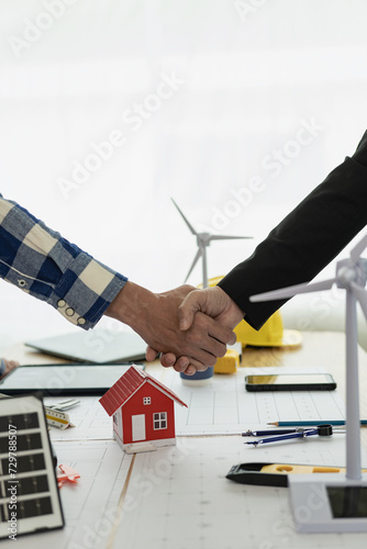 Architect and construction engineer holding hands while working for teamwork and cooperation concept after completing an agreement on construction site. Close-up pictures