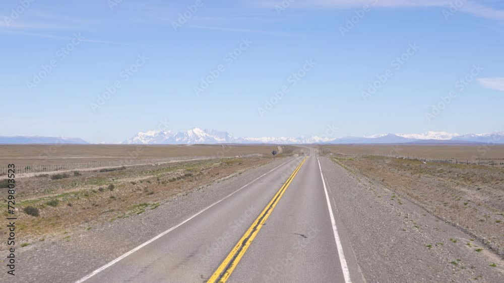 View of Torres Del Paine in the distance from a front window inside of a moving car View of Torres Del Paine in the distance from a front window inside of a moving car