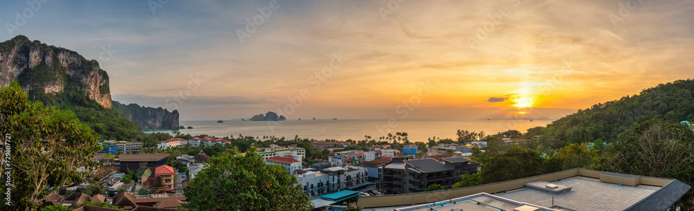 Fototapeta premium Tropical sea sunset at Ao Nang Beach with limestone mountain, Krabi Thailand high angle view nature landscape panorama