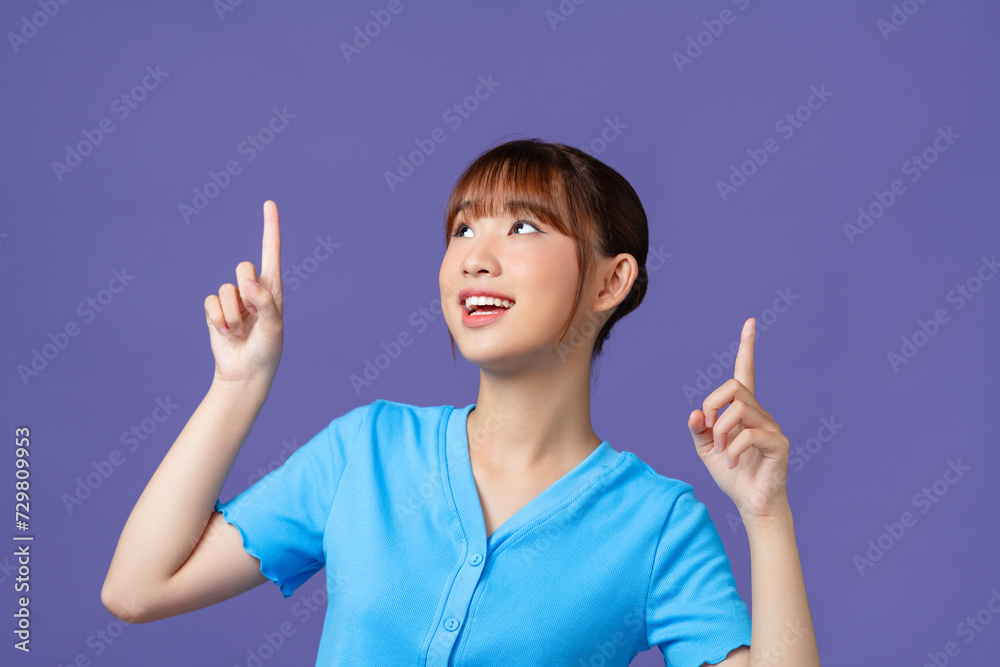 Young Asian woman showing and pointing up with fingers, inviting use link isolated purple background Young Asian woman showing and pointing up with fingers, inviting use link isolated purple background