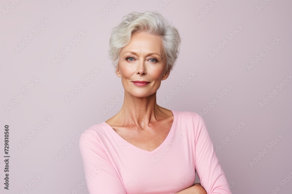 Confident senior woman. Beautiful mature woman looking at camera and smiling while standing against grey background Confident senior woman. Beautiful mature woman looking at camera and smiling while standing against grey background
