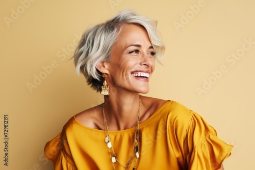 Portrait of a beautiful middle-aged woman with short grey hair in a yellow dress