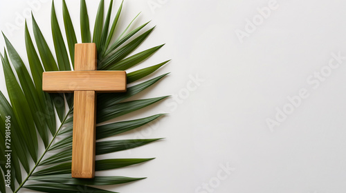 Palmsonntag Hintergrund - Einfaches Holzkreuz liegt auf grünem Palmblatt auf einem weißen Hintergrund