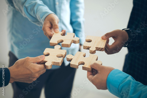 Concept of teamwork and partnership. Business hands join puzzle pieces in the office. business people putting the Jigsaw team together. Charity, volunteer. Unity, team business. business idea.CSR.ESG photo