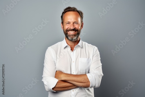 Handsome middle aged man in a white shirt on a grey background.