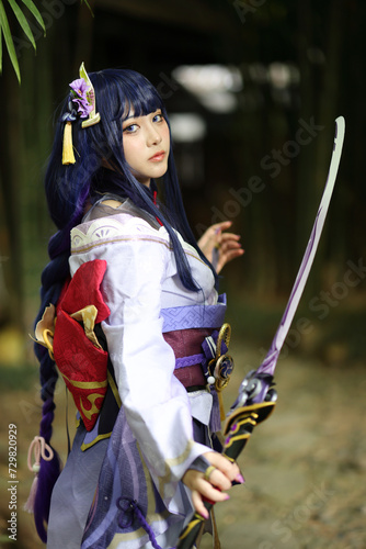 Portrait of a beautiful young woman game cosplay with samurai dress costume on Japanese garden