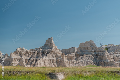 Multi-colored rock formations and mountains rising over the plains of Badlands National Park