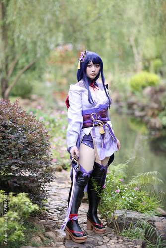 Portrait of a beautiful young woman game cosplay with samurai dress costume on Japanese garden