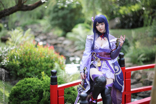 Portrait of a beautiful young woman game cosplay with samurai dress costume on Japanese garden