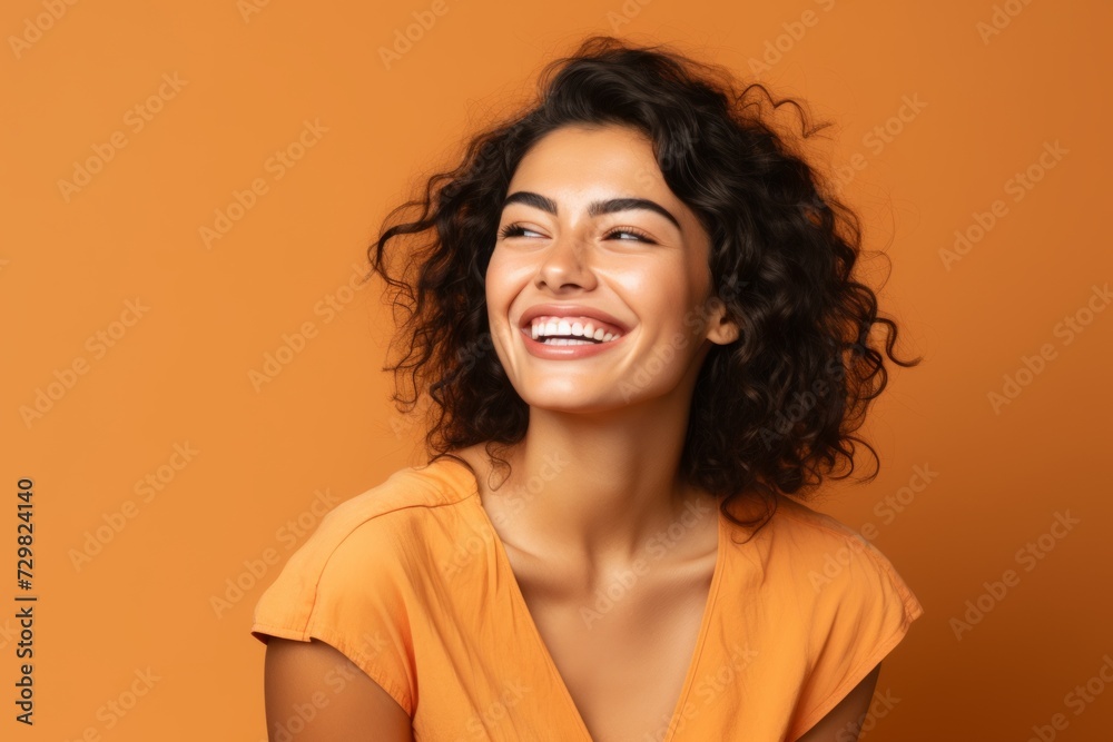 Portrait of a happy young woman with curly hair on orange background Portrait of a happy young woman with curly hair on orange background