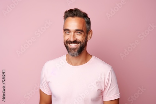 Portrait of a handsome middle-aged man with a beard on a pink background