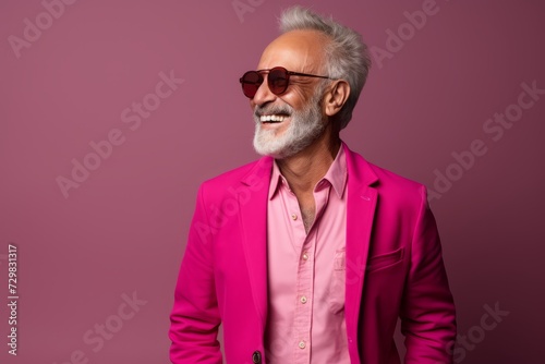 Portrait of a stylish senior man in pink suit and sunglasses.