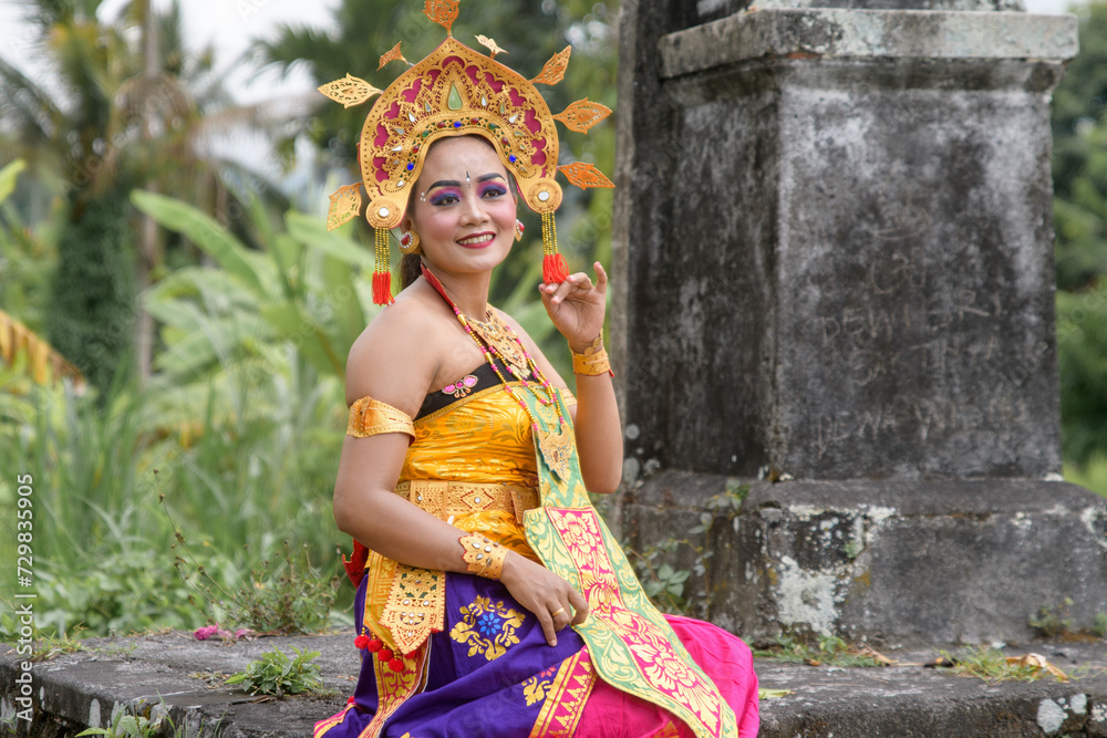Portrait a woman in traditional Balinese attire performing a cultural dance.