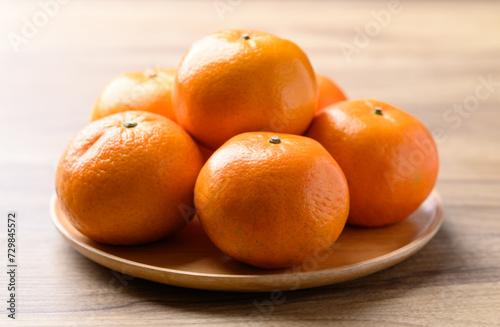 Mandarin orange fruit on wooden plate, Tropical fruit