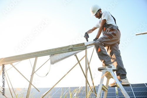 Fototapeta Naklejka Na Ścianę i Meble -  An Indian worker installs solar panels. The concept of renewable energy.