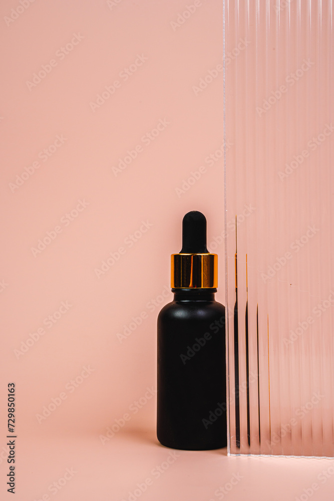 Hair oil is behind glass. Massage oil on a pink background. A bottle of cosmetics.
