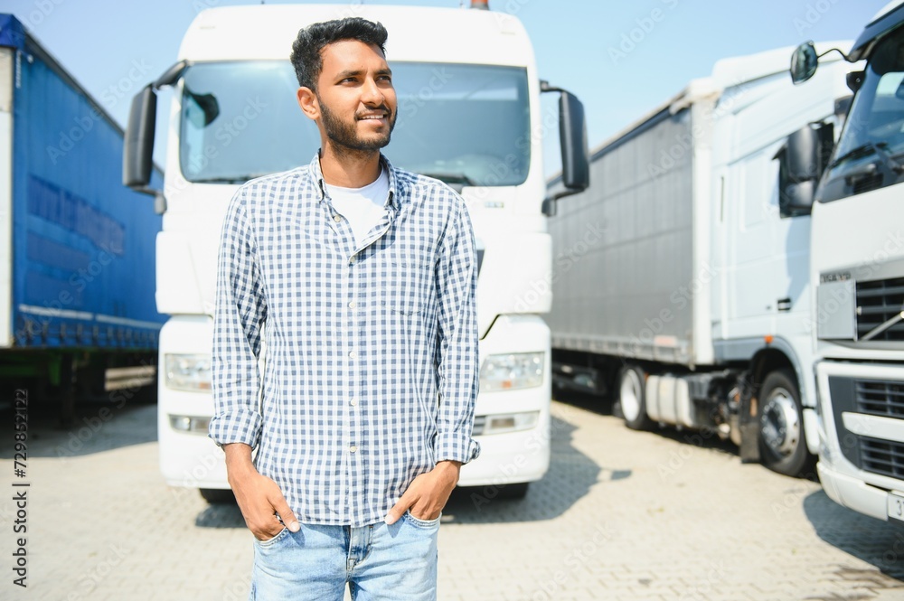 Young indian man standing by his truck. The concept of freight transportation. Young indian man standing by his truck. The concept of freight transportation.