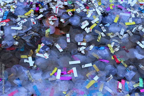 Pélissanne, France, May 21 2023 : Multicolored party favors on a wet asphalt ground. Beautiful abstract composition. photo