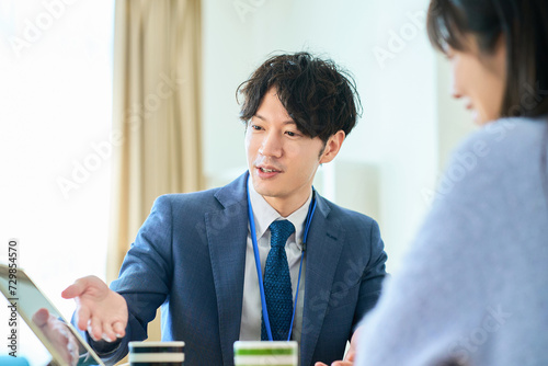 女性に向かって話すスーツ姿の男性 photo