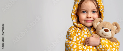 A Little Girl Is Holding A Teddy Bear In Front Of Her Face
