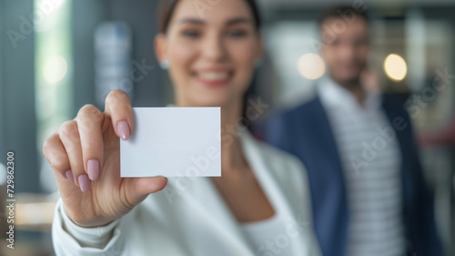 A Woman Is Holding A Business Card In Front Of A Man In A Suit