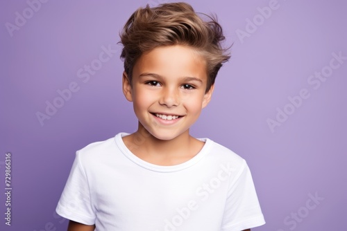 Portrait of a cute little boy in a white t-shirt on a purple background