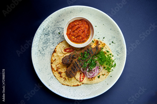 Turkish Lula kebab with pita bread and sauce in a plate