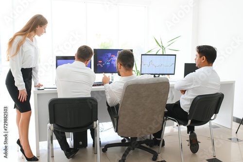 Team of brokers is working in office using workstation and analysis technology.
