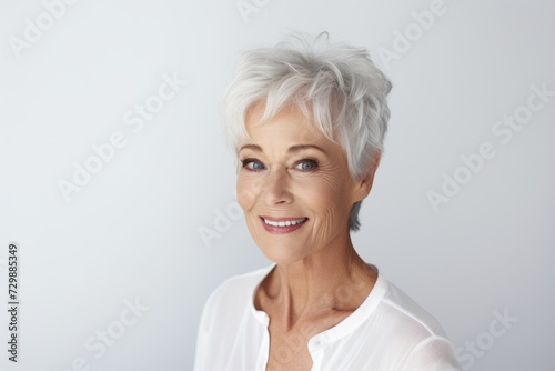 Portrait of a happy mature woman smiling at the camera, over grey background