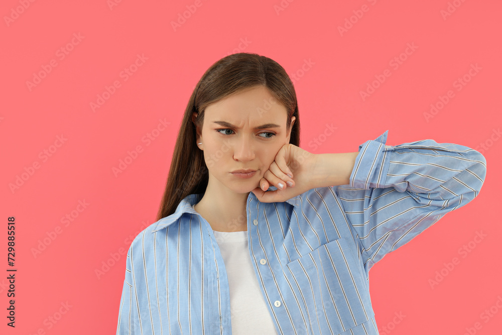 Fototapeta premium Attractive young girl stands on a pink background