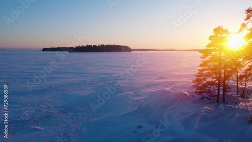Aerial view circling over snowy sea ice, winter sunset in the Finnish archipelago photo