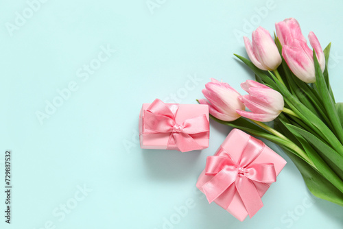 Pink tulips with gift boxes on blue background © Pixel-Shot