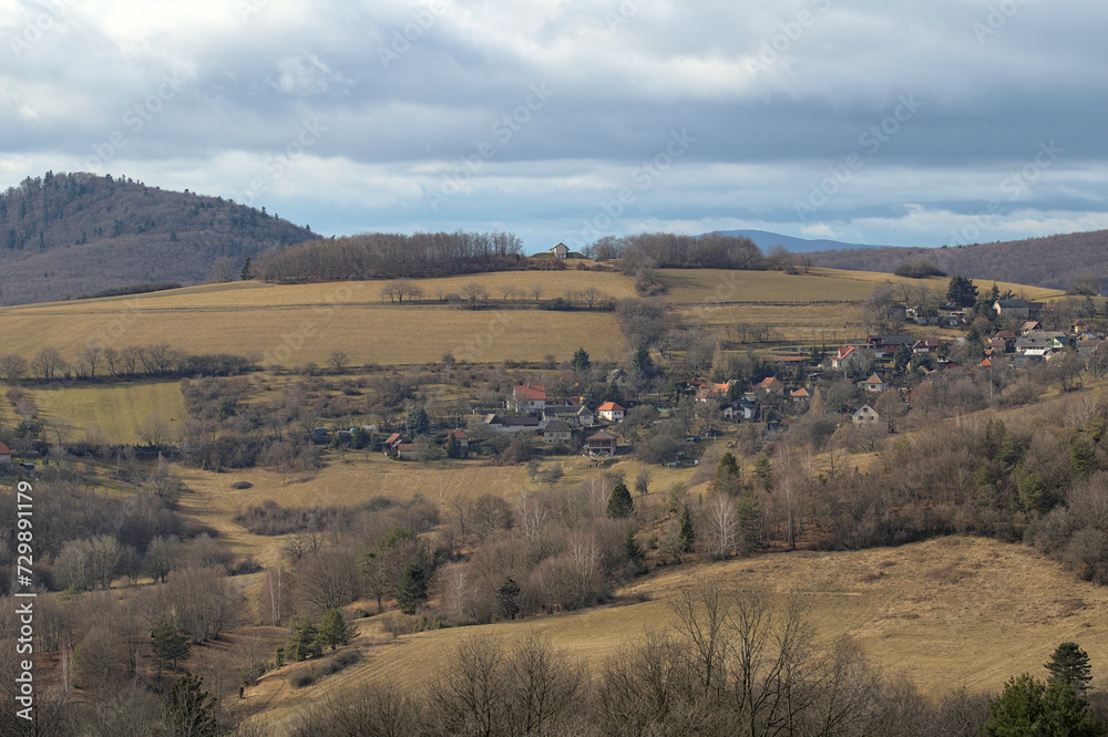 a village surrounded by meadows under a cloudy sky a village surrounded by meadows under a cloudy sky