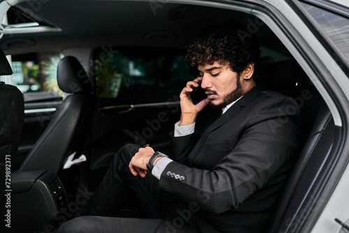 Curly Haired Businessman Backseat Talking Phone © Rimsha