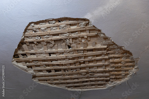 Collapsed plaster from the white ceiling in the interior of an old house.