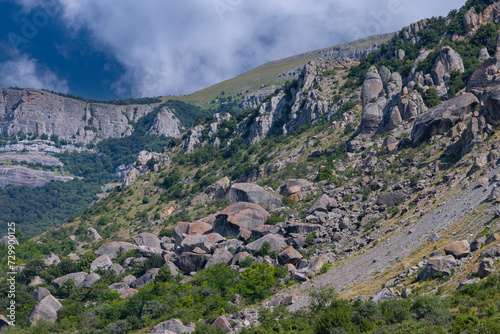 Mountain landscape, rocks with collapsed huge boulders against a sky with clouds. photo