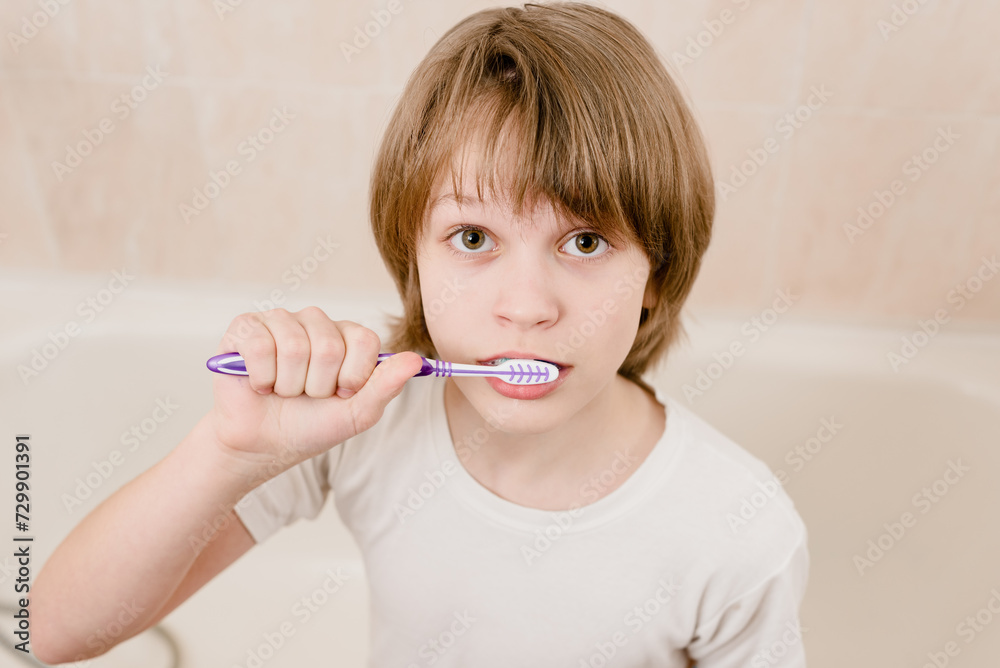 Smiling teenager boy with toothbrush cleaning teeth in the morning, Healthy habits: Young boy cares for his teeth, applying toothpaste in the morning Smiling teenager boy with toothbrush cleaning teeth in the morning, Healthy habits: Young boy cares for his teeth, applying toothpaste in the morning