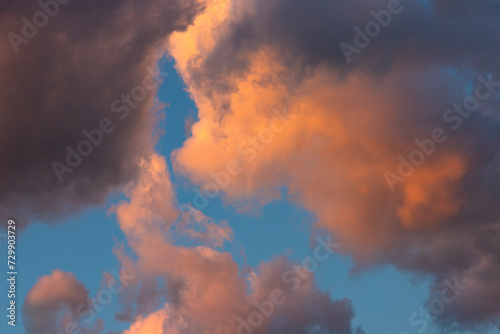 Cloud landscape. Pink and brown summer cumulus clouds on a blue sky during sunset. Wallpaper. Background.