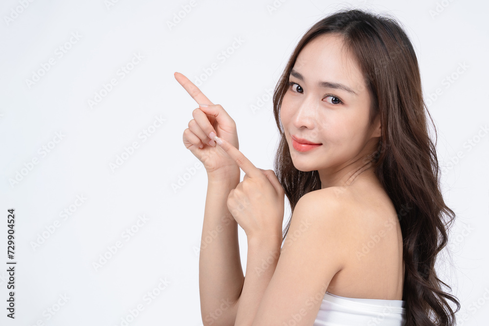 Asian woman with natural makeup point a finger to the side. Surgery and Cosmetology concept with white background. Asian woman with natural makeup point a finger to the side. Surgery and Cosmetology concept with white background.