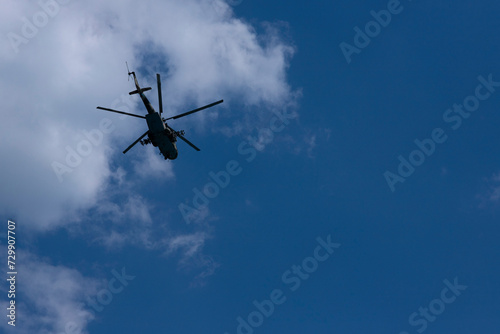 Military Russian helicopter flies in the sky. Bottom view.
