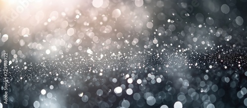 Sparkling silver particles with bokeh creating an abstract background. Festive dust for Christmas and New Year. photo