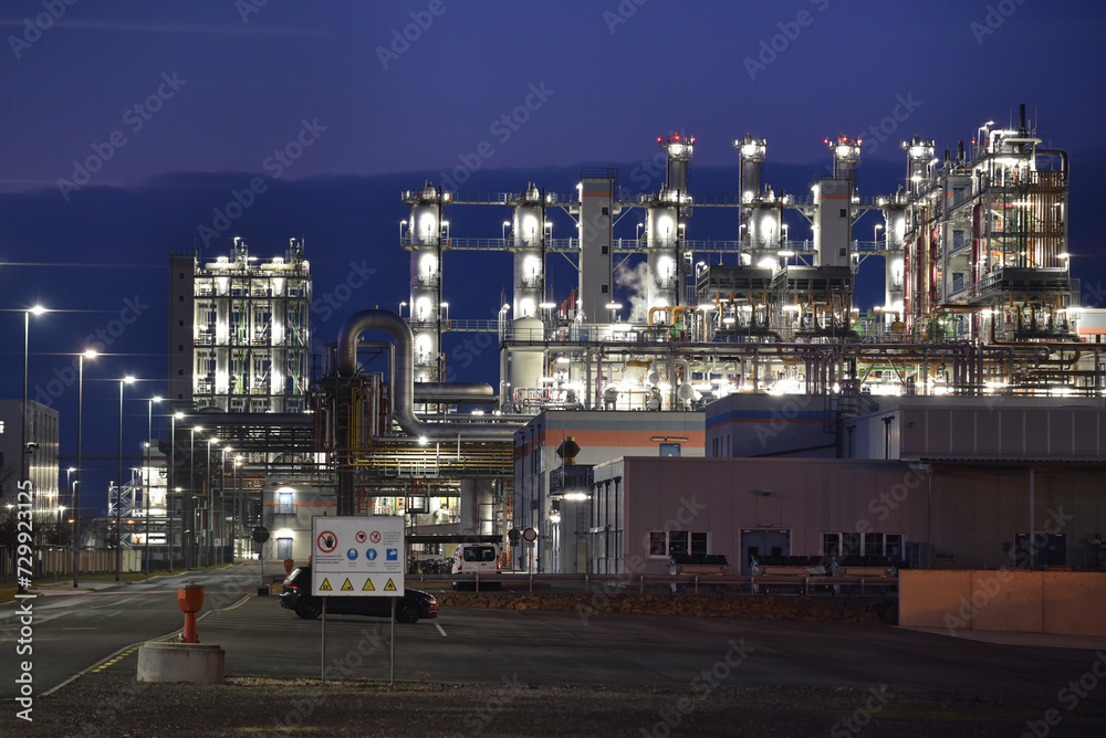 chemical factory at night with buildings, pipelines and lighting - industrial plant