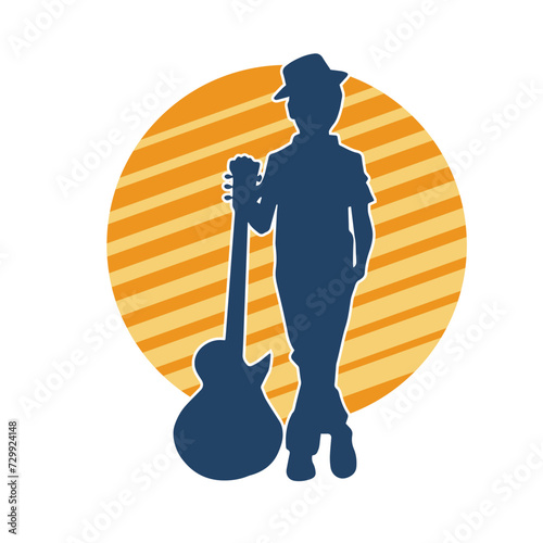 Silhouette of a young kid in pose with an acoustic guitar. Silhouette of a young musician in pose with acoustic guitar musical instrument.