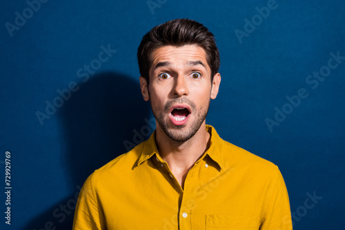 Photo portrait of attractive young man frightened face scream wear trendy yellow clothes isolated on dark blue color background © deagreez