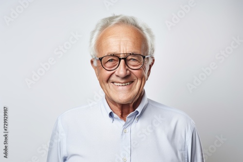 Portrait of smiling senior man in eyeglasses on grey background